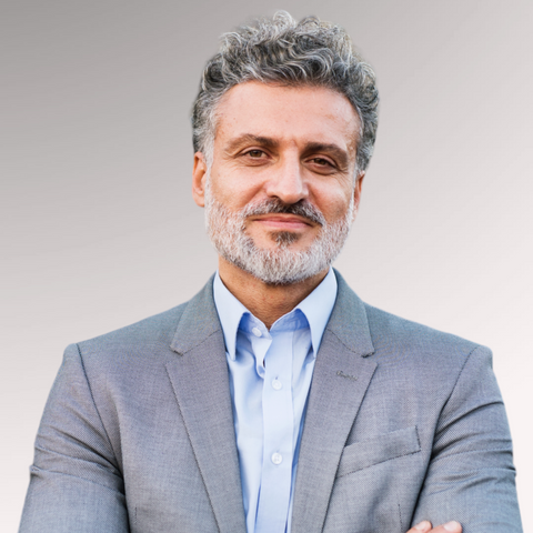 Man in a suit with gray hair demonstrating a curly taper men's professional haircut