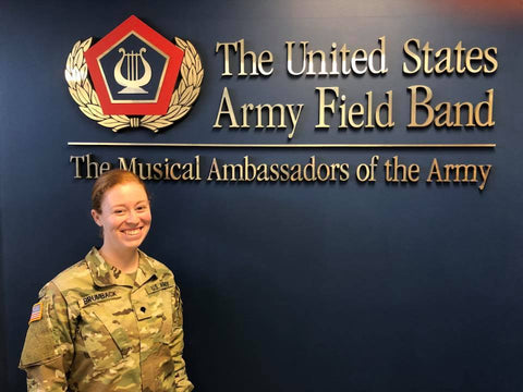 Madeline stands in front of army wall