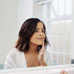 Woman applying cream to face