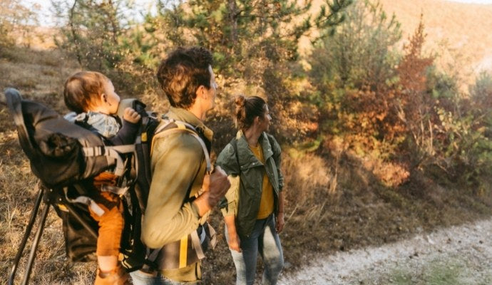 A mother and father hiking with baby