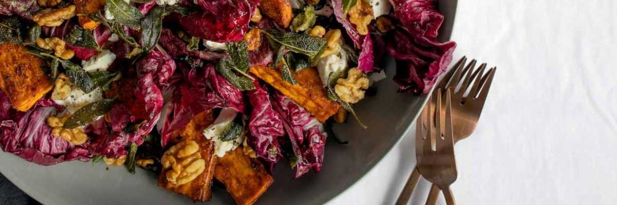 a close up of Radicchio Sweet Potato salad in a bowl with forks at the side