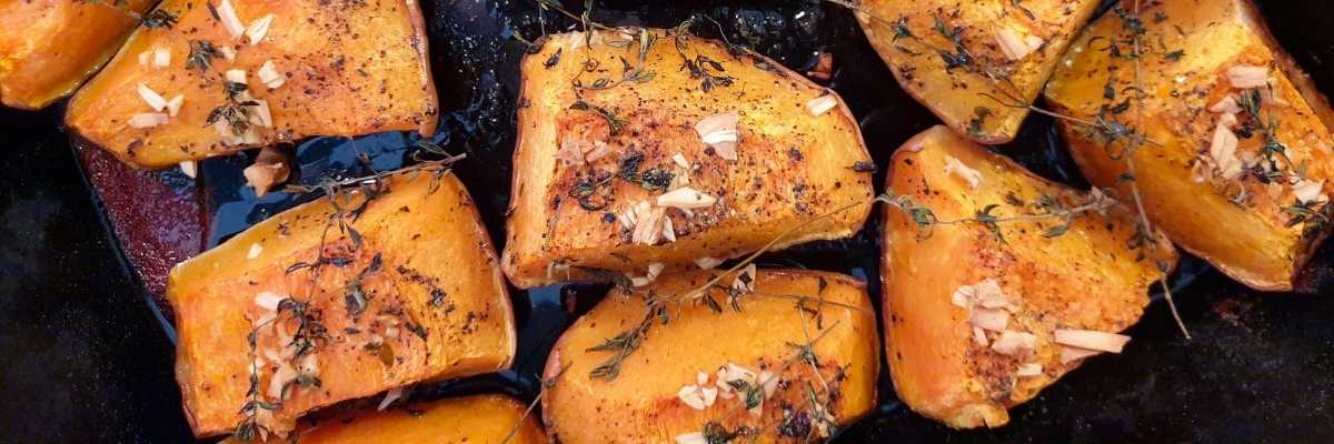 Roast pumpkin on a baking tray with herbs