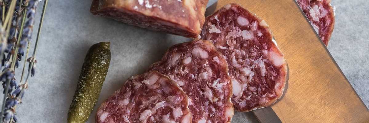 homemade salami slices with a cornichon