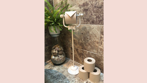 A chic freestanding toilet roll holder with a weighted bottom