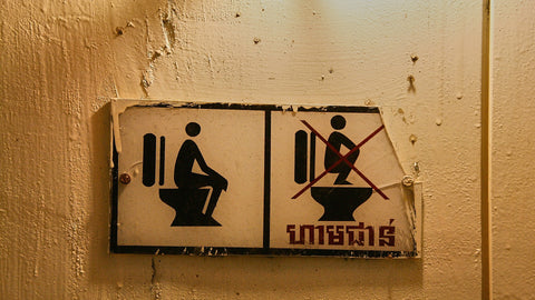 No squatting sign on toilet wall