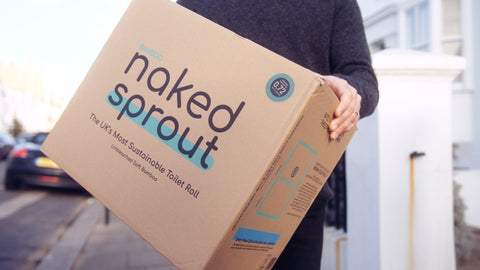A man carrying a box of Naked Sprout toilet rolls