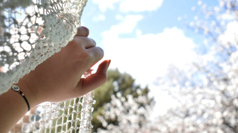 a hand parts a pretty lacy curtain