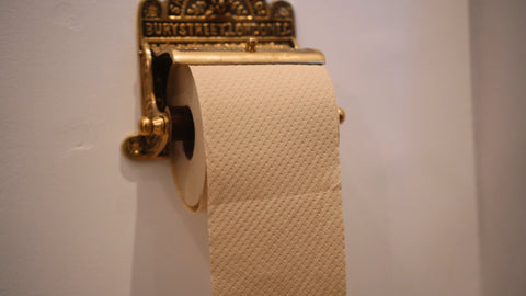 Naked Sprout unbleached toilet roll in a gold toilet roll holder