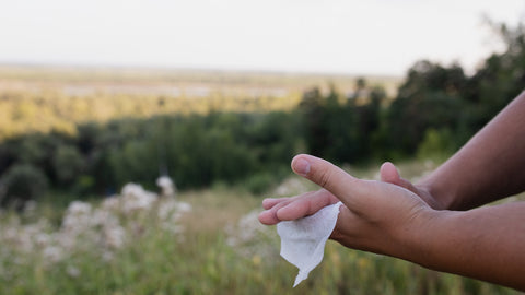 using a tissue to wipe hands in the countryside