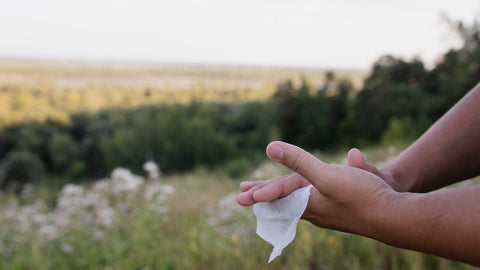 someone wiping their hands with a tissue outside