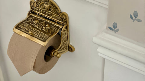 An elegant gold antique style toilet roll holder