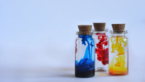 bottles of water with drops of ink in them