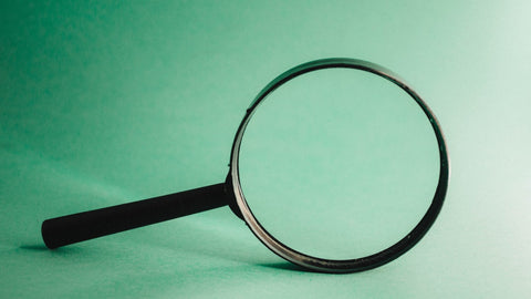 A magnifying glass against a green background