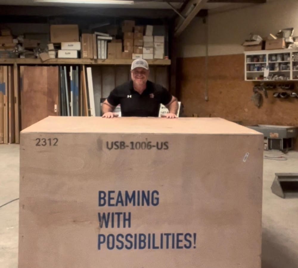 man standing next to laser engraver crate