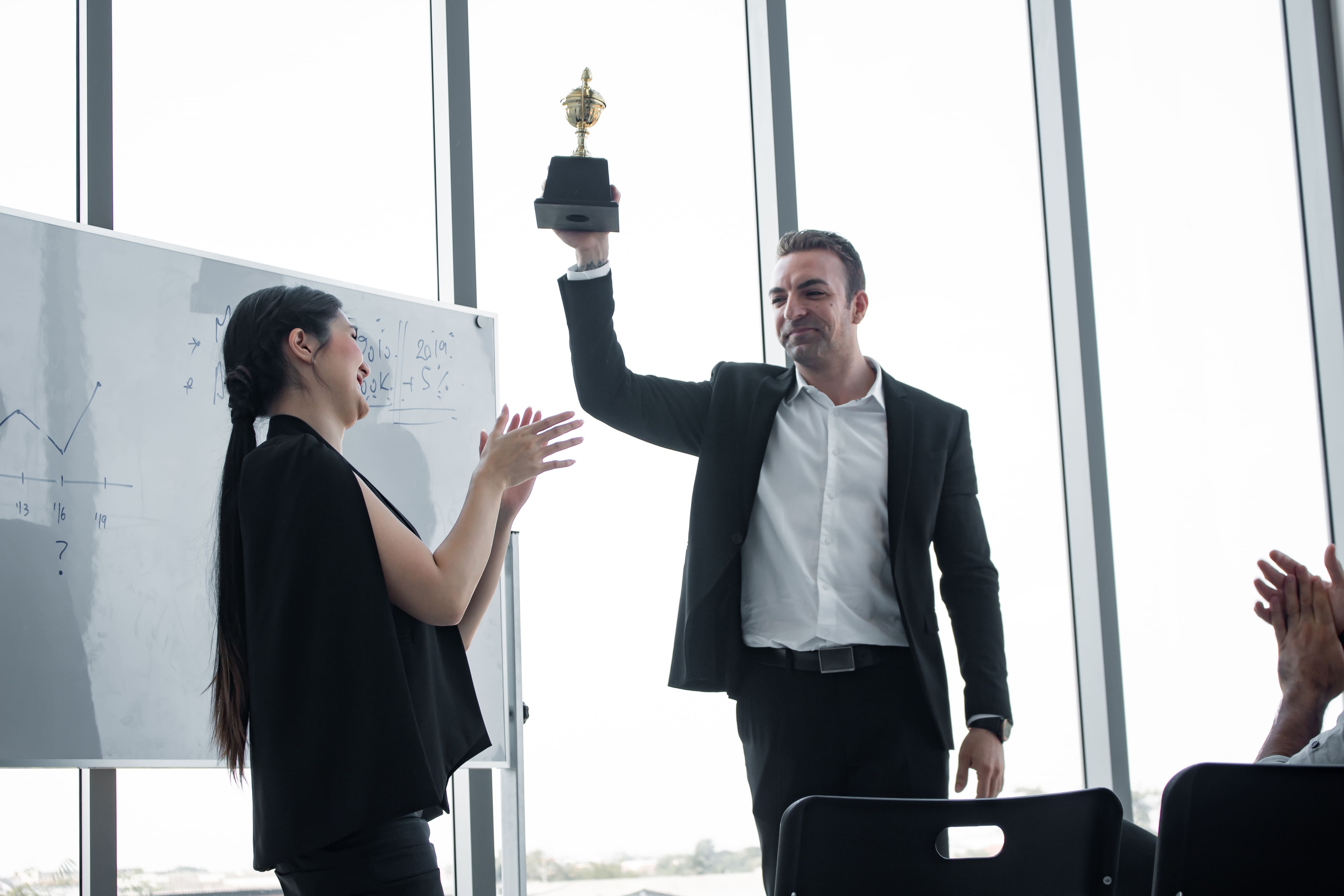 corporate man celebrating with a custom engraved trophy