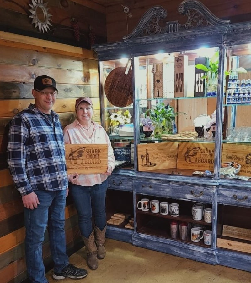 couple standing in front of laser engraved wooden products
