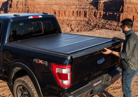 Man opening the tonneau cover on a Ford F150.