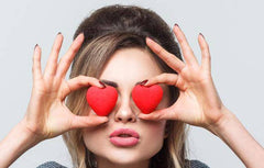 woman looking through heart shaped glasses