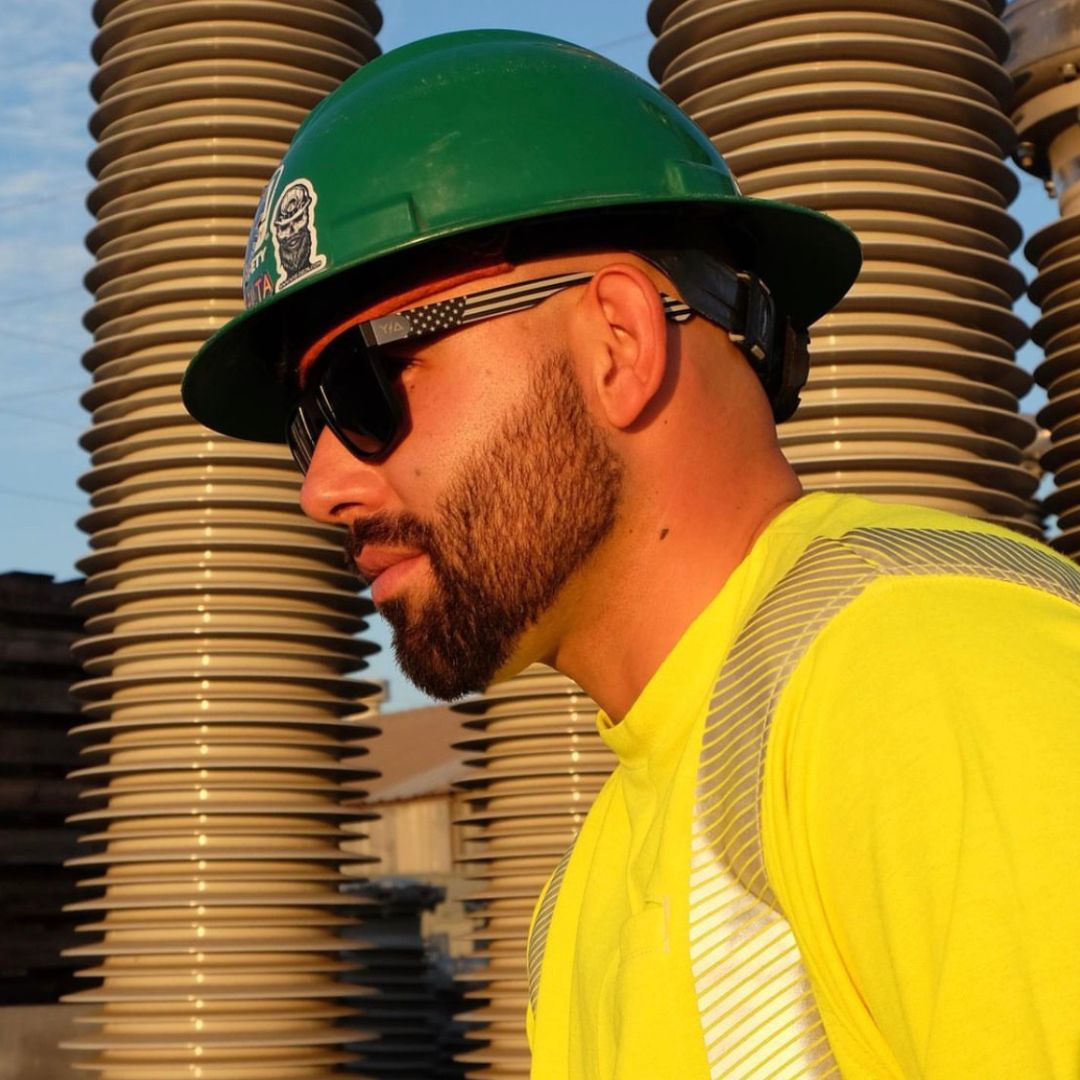 man on construction site wearing hard hat and safety glasses