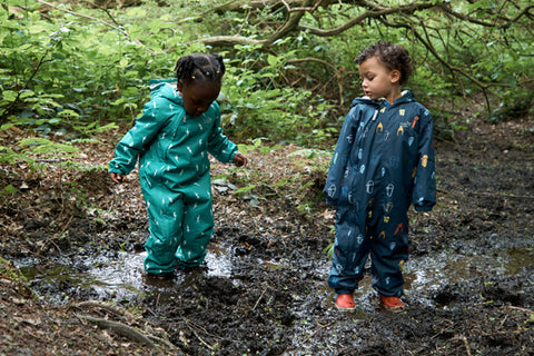children jumping in muddy puddle