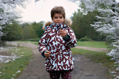 boy wearing burgundy parka in frosty woodland