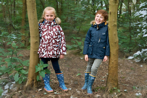 children wearing parkas in frosty woodland