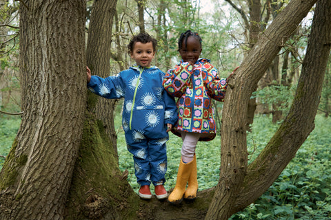 children wearing muddy puddles waterproofs in tree