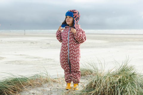 girl wearing waterproof puddlesuit at beach