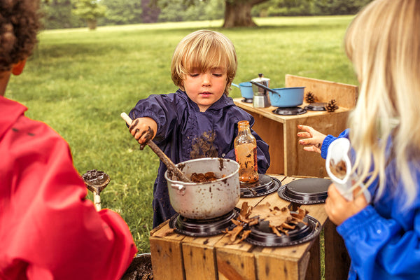 boy playing with mud kitchen