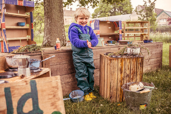 boy playing with mud kitchen