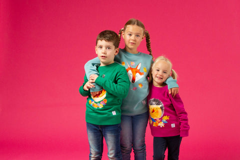 3 Kindermodels in bunten nachhaltige Sweathsirts mit den Motiven Fuchs, Igel und Eichhörnchen