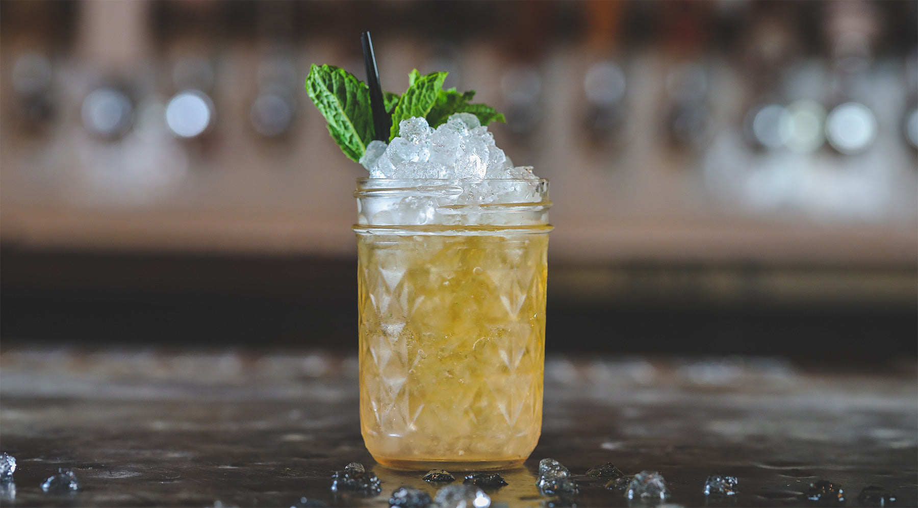Mason jar with cocktail and mint leaves