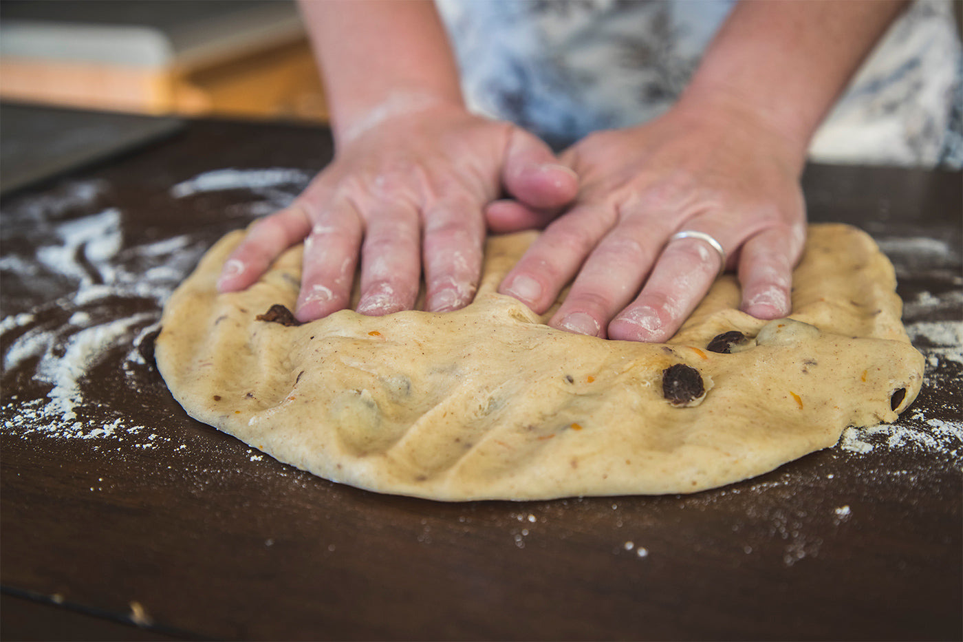 Hands pressing into dough