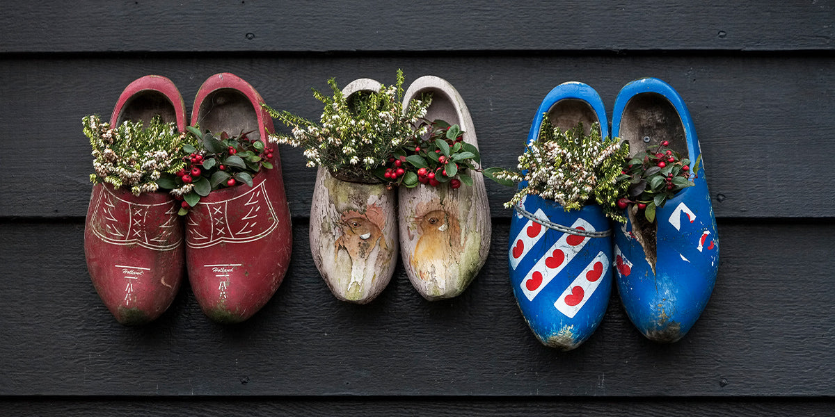 Three pairs of wooden clogs with holly in them