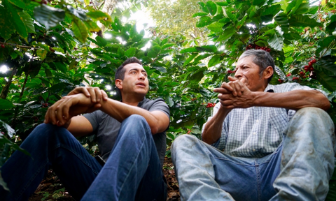 Martín Mayorga conversa con caficultor en una finca cafetalera en América Latina