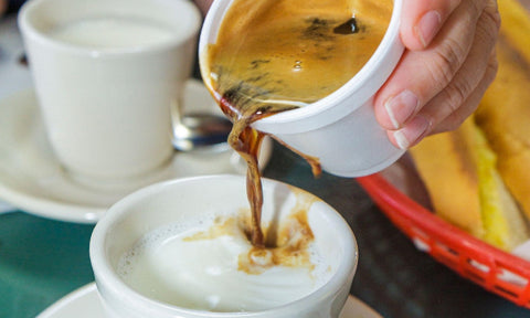 Espresso being poured into hot milk to make a cafe con leche