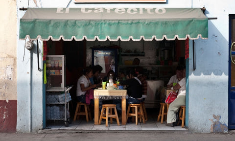 Streetside café in Cuba with an awning that reads 