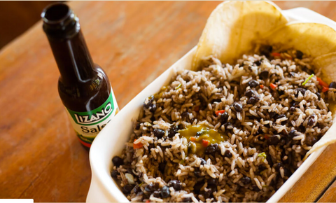 A bottle of Lizano Salsa, or Lizano sauce, next to a tray of Costa Rican gallo pinto