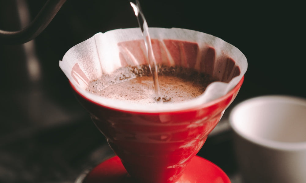 organic decaf coffee being poured through a coffee filter