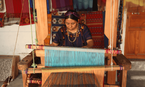 Mujer usando telar antiguo y tradicional para tejer un tapiz