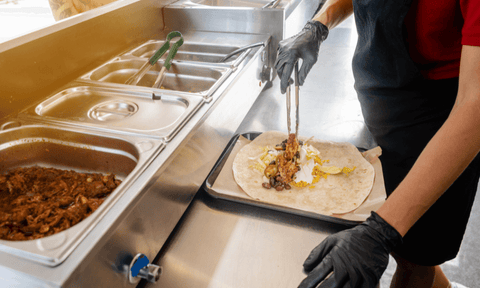 A chef prepares a burrito 