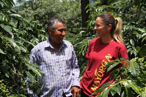 Female Mayorga Coffee employee laughing with a Central American coffee farmer