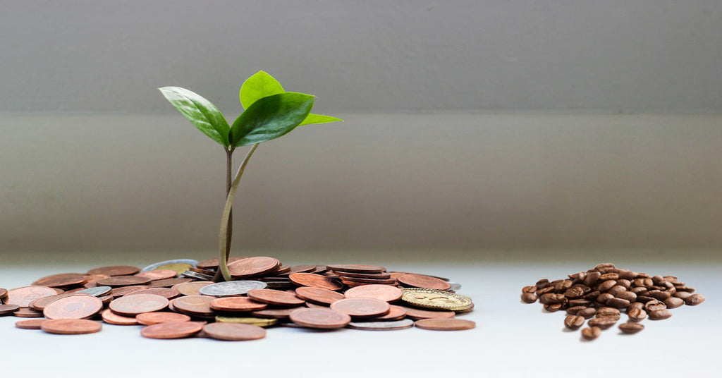 Pile of coins and coffee beans cost of specialty coffee