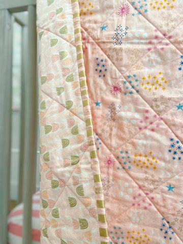pink and gold binding fabric on rainbow quilt
