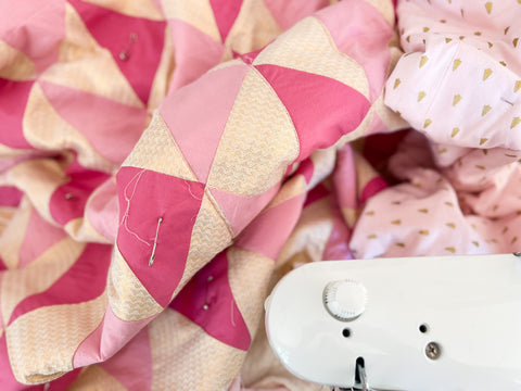 pink and gold christmas quilt on sewing machine