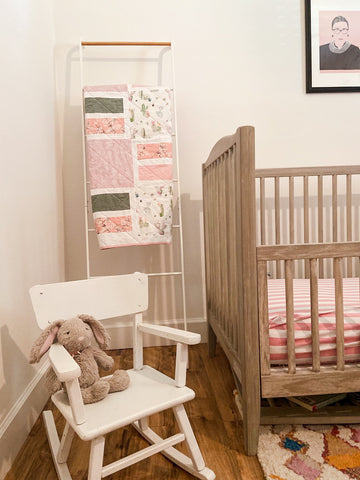 pink and green baby girl quilt in nursery