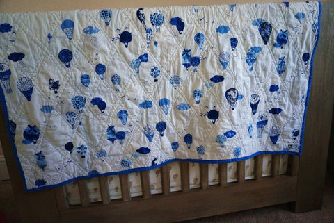 blue hot air balloon quilt in a nursery