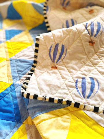 black and white striped fabric binding on baby quilt