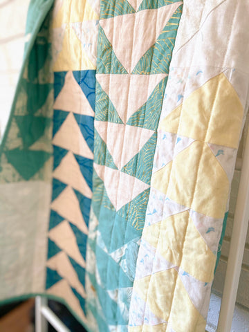custom baby quilt with soft greens, yellows, and blues