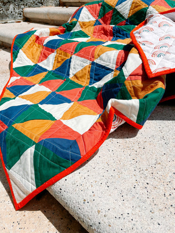 gender neutral baby quilt laying on steps outside